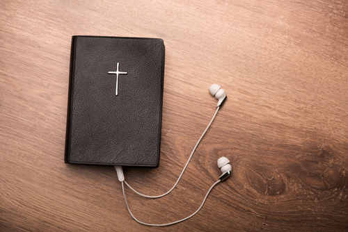 Close up of a Bible connected with earphones